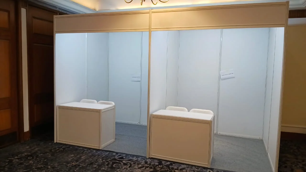 Dua unit booth modular berdampingan di ballroom lengkap dengan meja counter dan lantai karpet