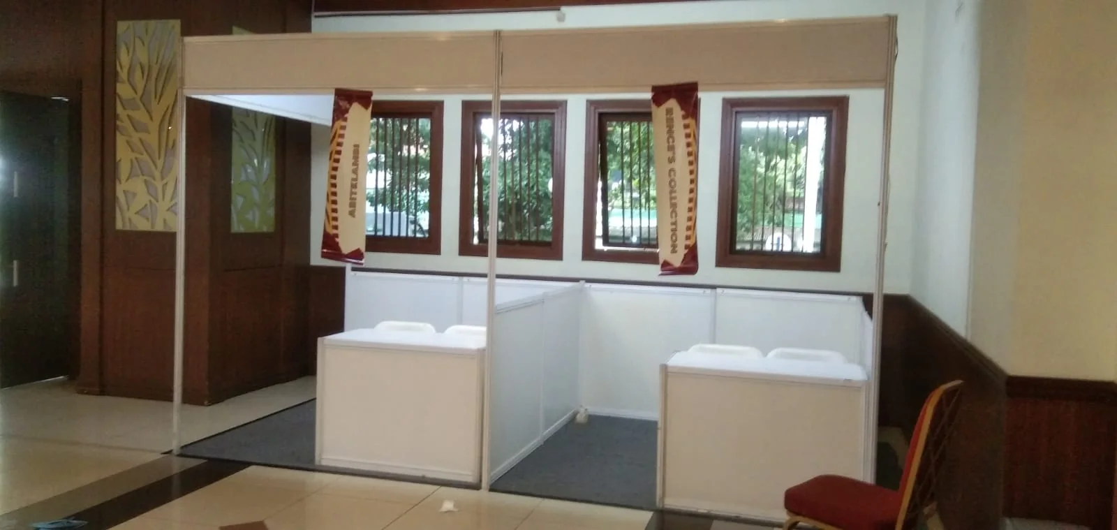 Booth registrasi dua counter di area lobby dengan partisi putih dan ruang pelayanan terpisah