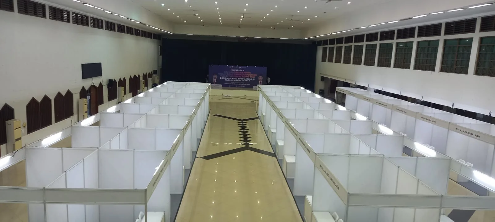 Deretan booth pameran modular Eventara Indonesia dengan pencahayaan fascia dan jalur pengunjung yang rapi