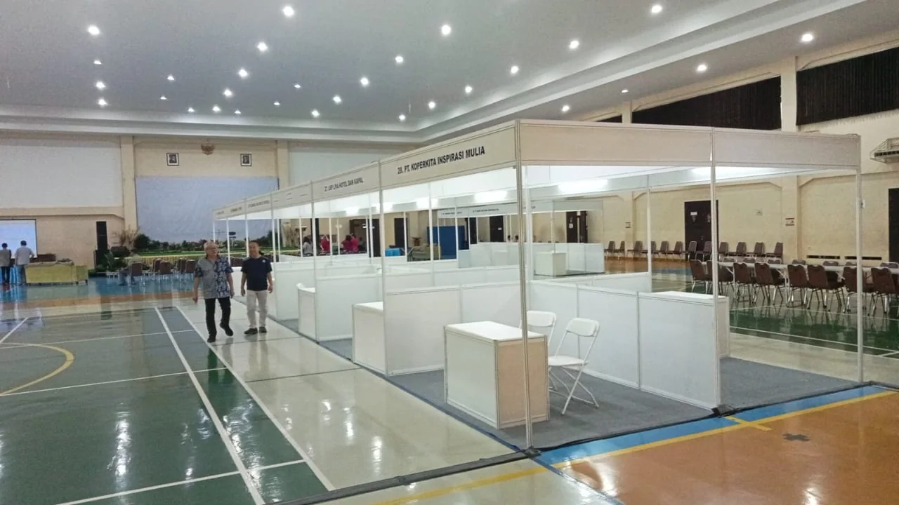 Proses instalasi booth event indoor dengan sistem panel modular yang rapi dan dapat digunakan ulang
