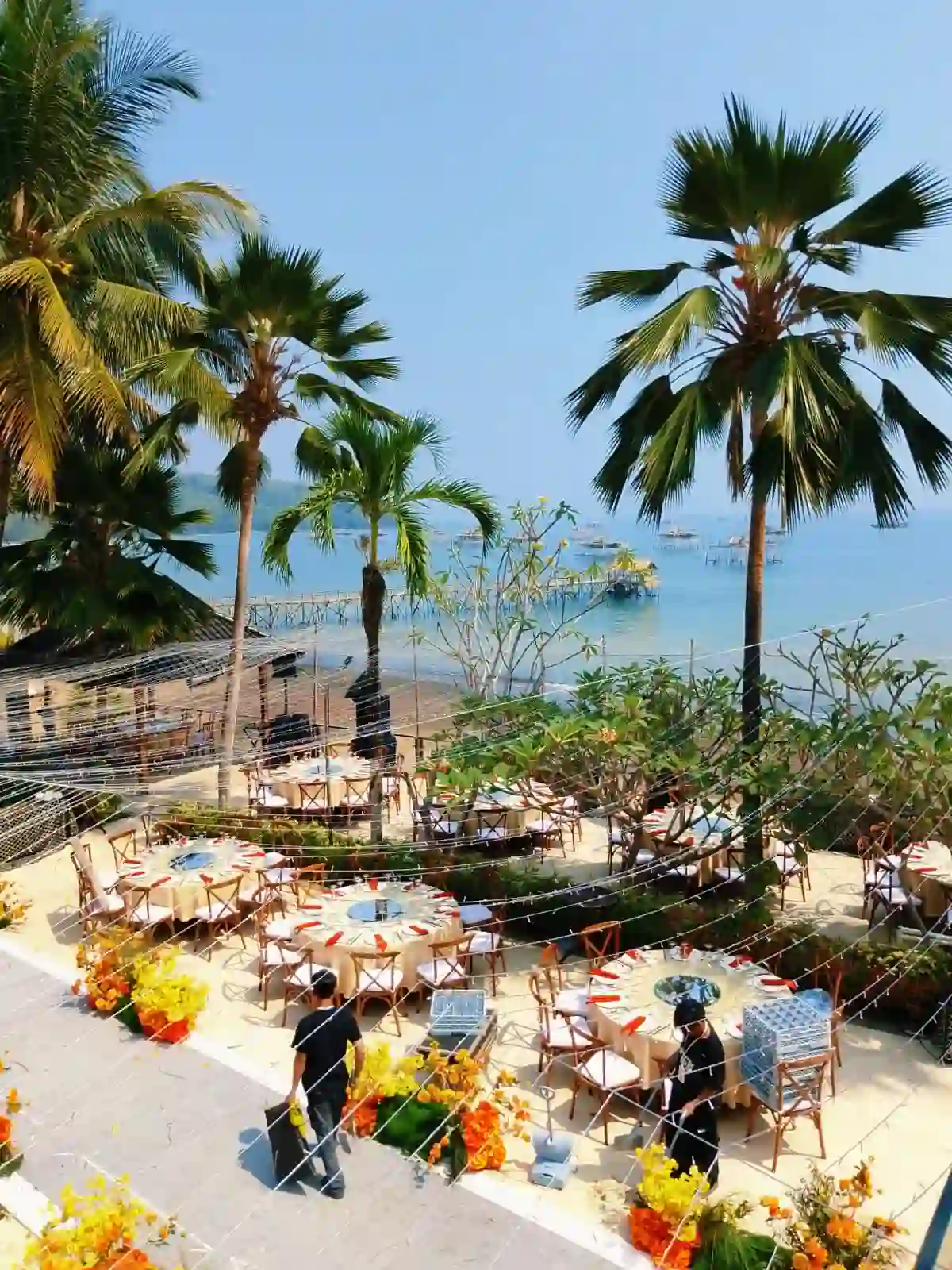 Tenda transparan dengan chandelier kristal, dekorasi greenery gantung, dan meja pengantin panjang untuk private wedding tepi pantai, instalasi Eventara Indonesia, 15 Agustus 2026