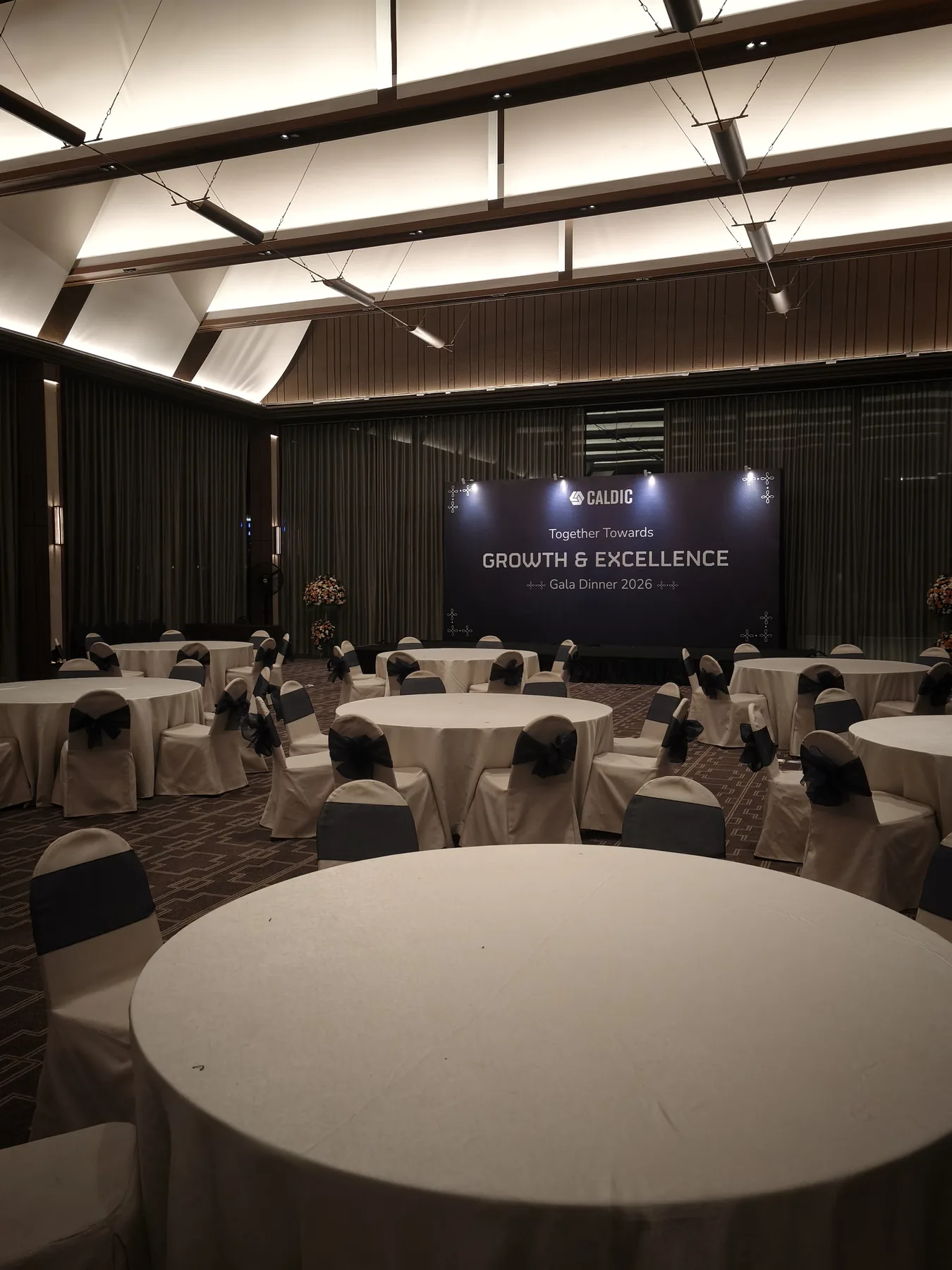 Ruang banquet Gala Dinner Caldic dengan meja tamu dan panggung bertema Growth & Excellence