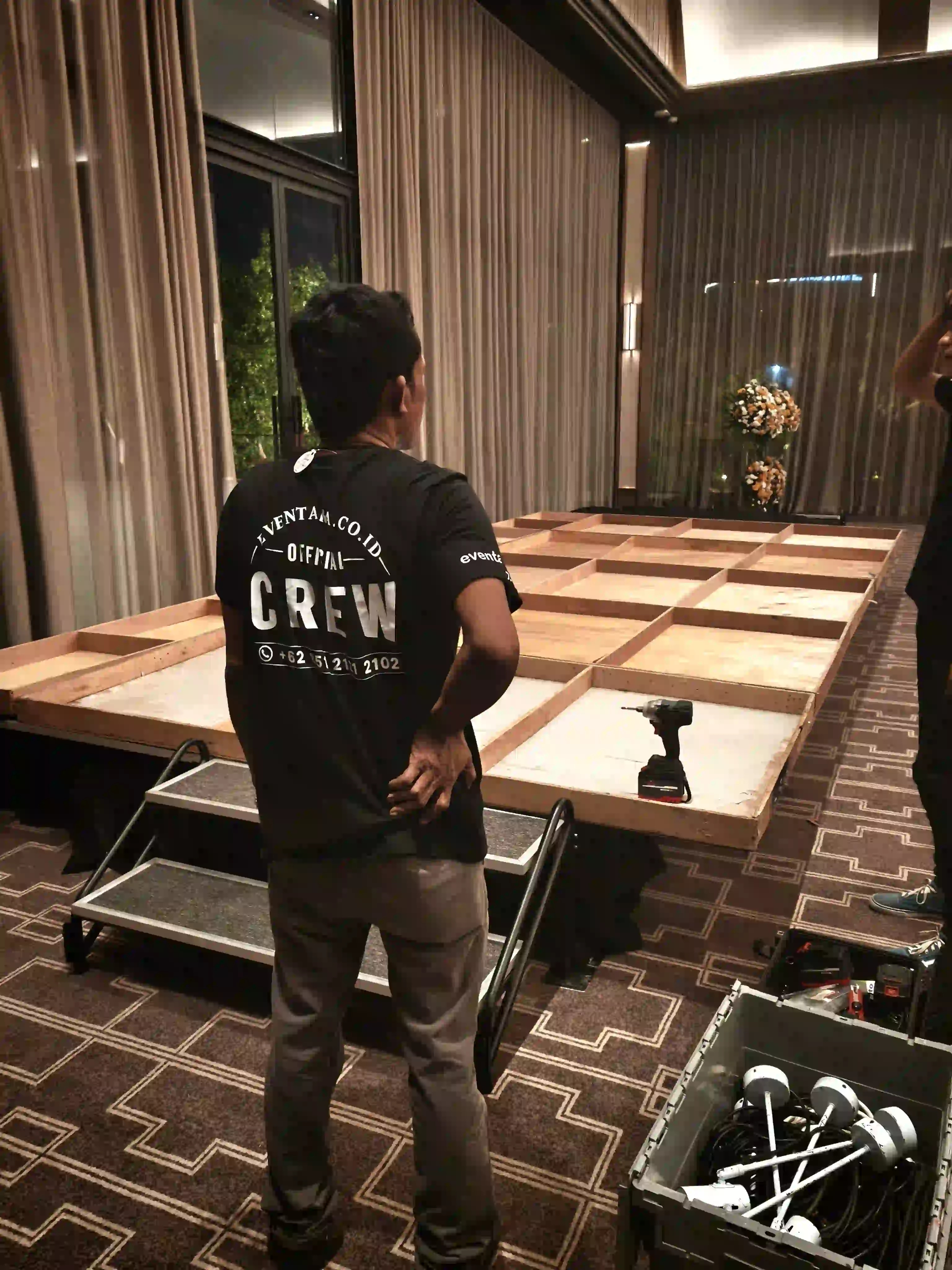 Kru Eventara  menyiapkan platform panggung untuk Gala Dinner Caldic