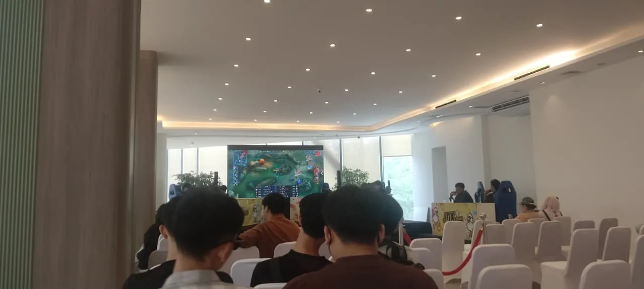 Penonton mengikuti pertandingan Mobile Legends dari layar utama venue