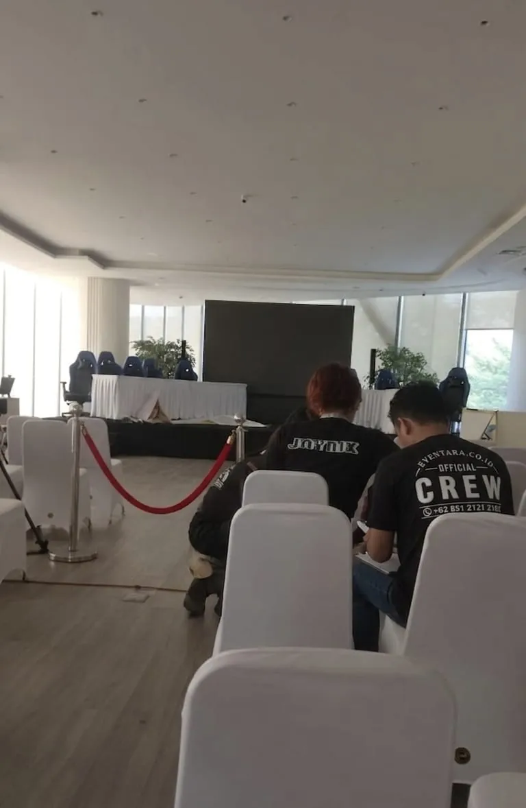 Kru event menyiapkan area dan kursi sebelum turnamen esports dimulai
