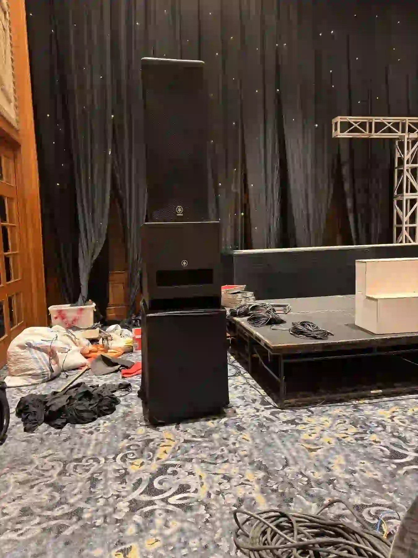 Speaker, backdrop hitam, dan peralatan audio di area panggung Aryaduta