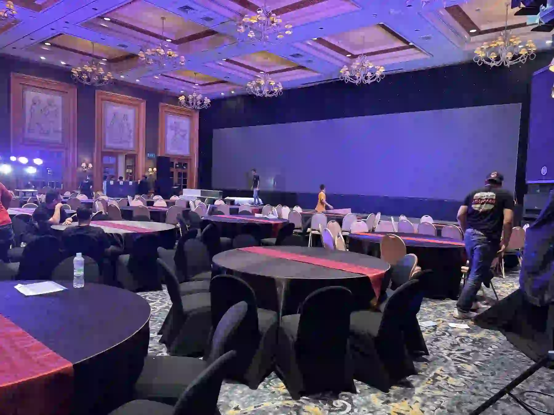 Pengunjung berada di ballroom dengan panggung dan pencahayaan ungu