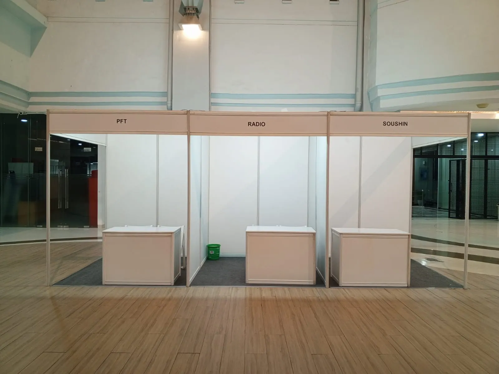 Booth putih dan meja display yang disiapkan untuk tenant bazar kampus